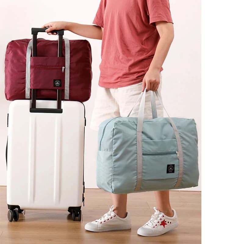 The duffel bag in Blue being carried by the handles