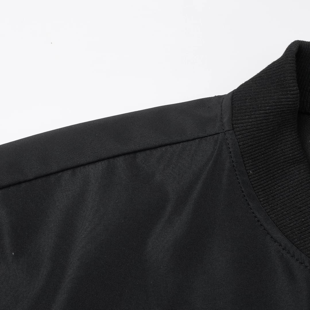 Collar and shoulder detail of the baseball jacket showing fabric texture and stitching