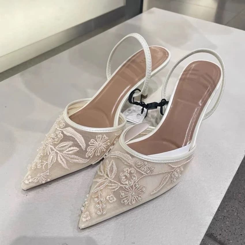 White mesh embroidered high heels with back strap on display