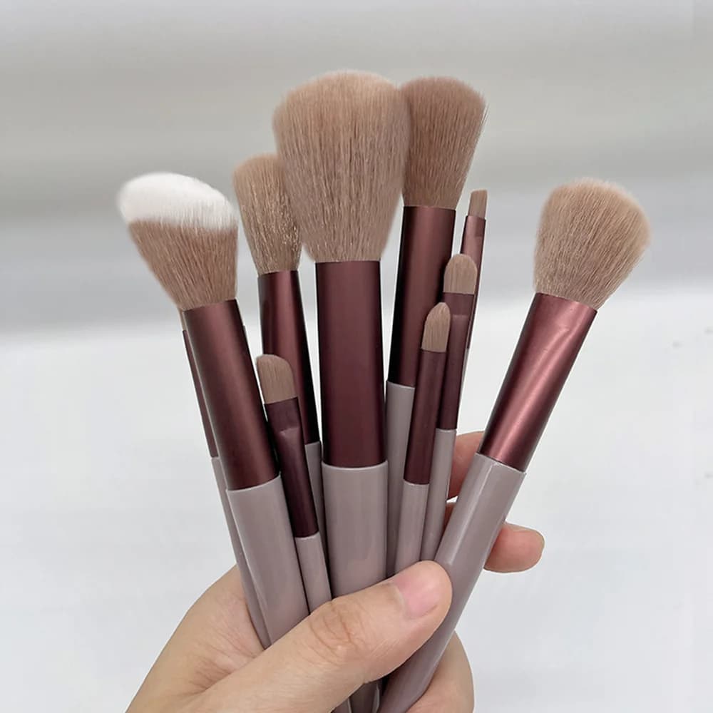 Rose gold fan makeup brush held in hand, fan bristles spread